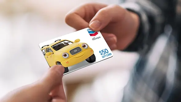 Chevron gas gift card being handed to someone.