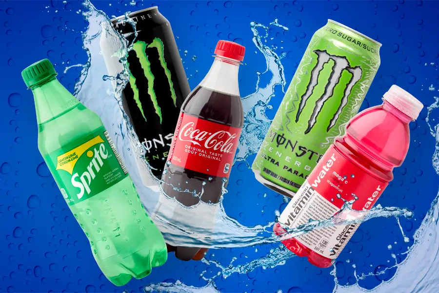A collection of bottled and canned drinks with water splashing between them.