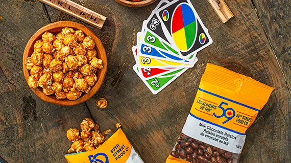Snacks and boardgames on a wooden table.