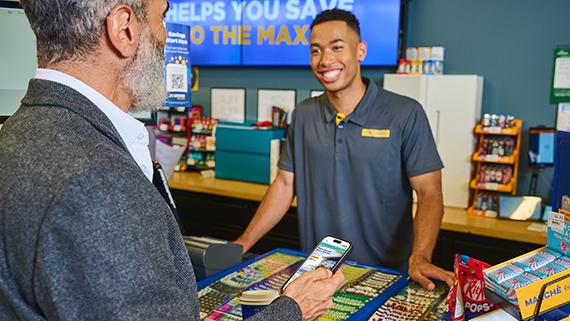 Convenience store employee assisting a customer.